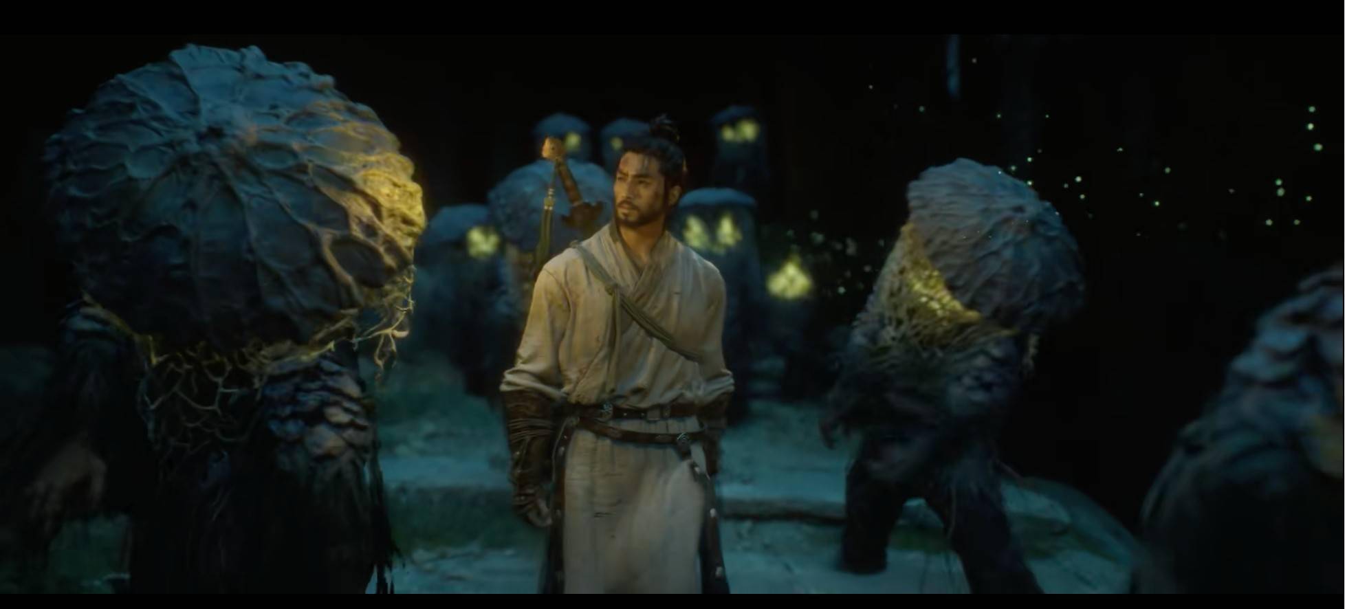 The swordsman stands among summoned little ghosts with glowing golden eyes